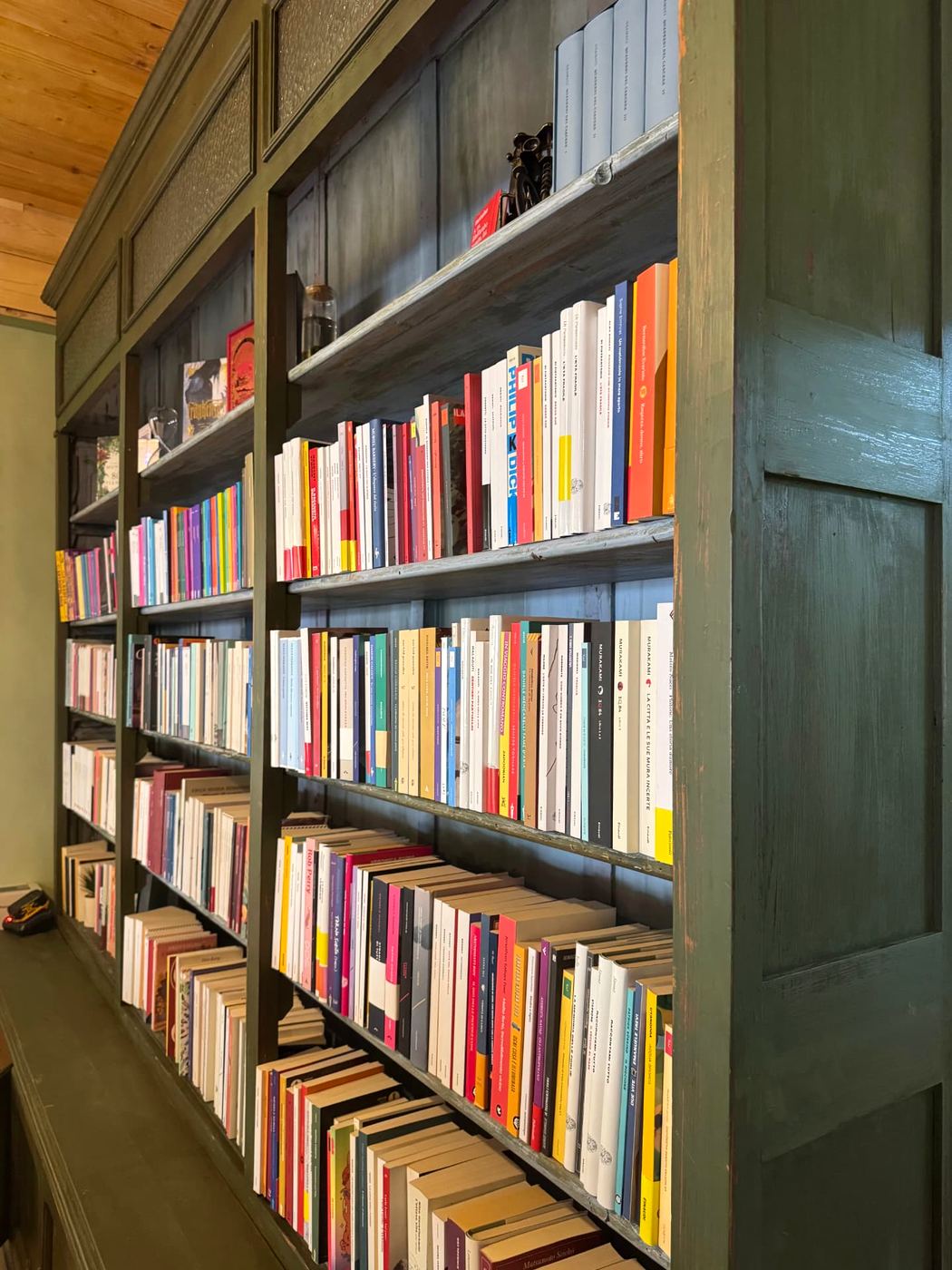La libreria di Nota a Margine: scaffali verde salvia pieni di libri